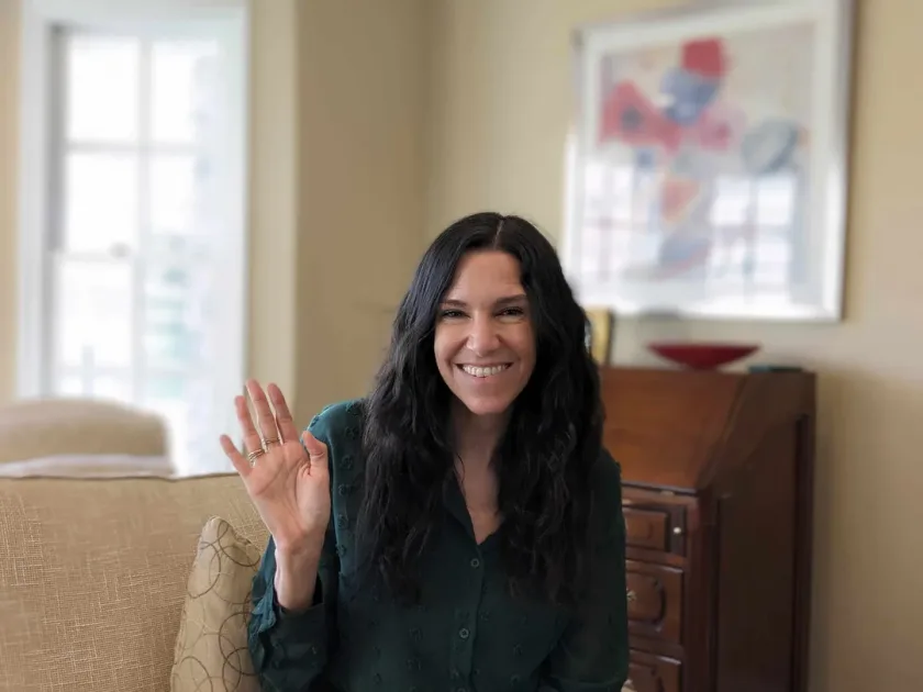 A young mom holds her newborn baby during a heartfelt online therapy call, showcasing love and connection.